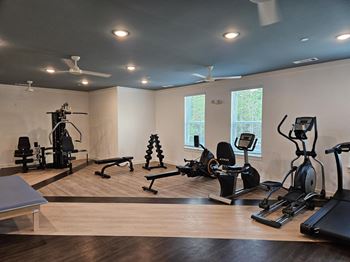 Ovata at Reedy Creek's fitness center, featuring a multi-gym station, a leg extension machine, dumbbells, a rowing machine, a stationary bike, an elliptical and a treadmill.